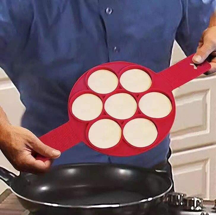 Seven mini pancakes held in the Flip n Cook silicone mould using its two handles