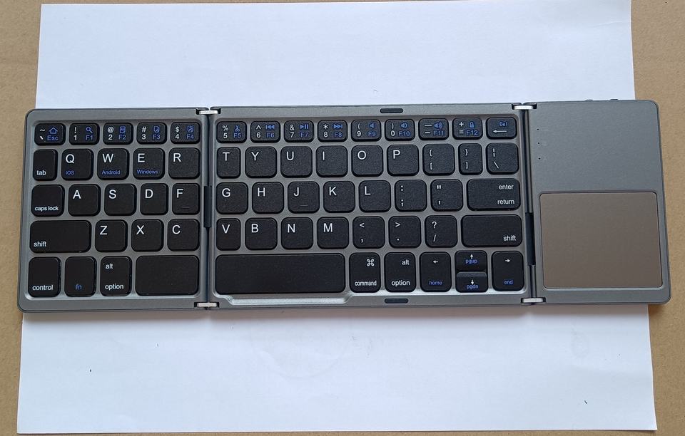 Foldable Bluetooth keyboard open with QWERTY keys and touchpad