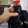 Rear view of a GEEMY GM-1017 hair clipper with a red blade guard, held in a hand